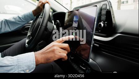Black Man Using Touchscreen Infotainment Panel In Modern Car Interior. Stock Photo