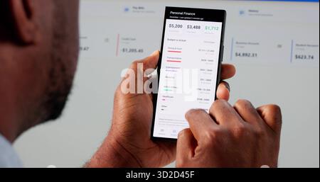 Young African American Accountant Using Smart Budget App On Phone. Stock Photo