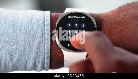 African American Man Attempts To Unlock Cyber Smartwatch For Security. Possible Professions: Cybersecurity Specialist Stock Photo