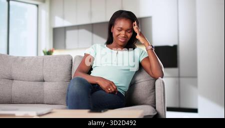 Portrait Of A Stressed African American Woman Holding Her Head. Psychiatric Therapy Session Stock Photo