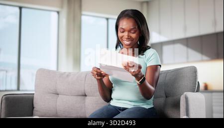 Excited Woman Reads Positive Letter, Smiling Joyfully At Good News. Stock Photo