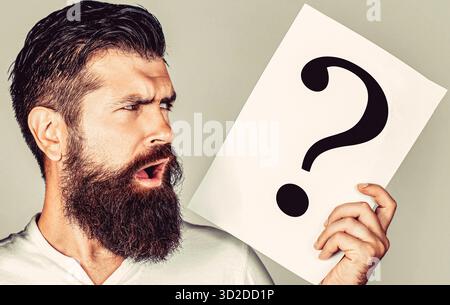 Man holding paper with question mark over isolated background scared in shock with a surprise face, afraid and excited with fear expression Stock Photo