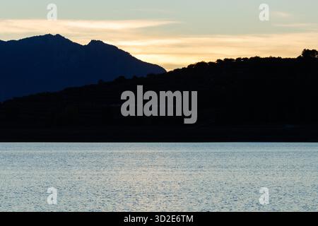 Sunset mountain silhouette background on the lake, Beniarres, Spain Stock Photo