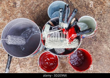 Empty paint buckets containing used rollers and brushes Stock Photo