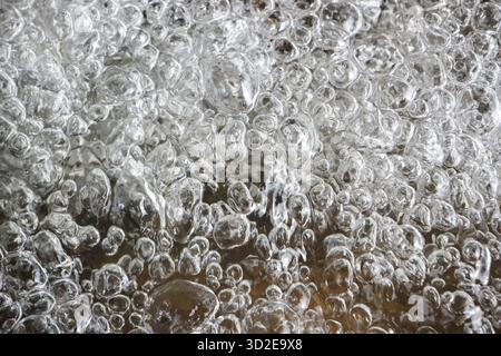 Close up of energetic boiling water with many transparent bubbles creating dynamic liquid background. refreshing and abstract texture of pure, powerfu Stock Photo