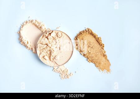 A chic example of the texture of a compact powder in a natural tone in a block and swatch on a blue background. top view. A copy space Stock Photo
