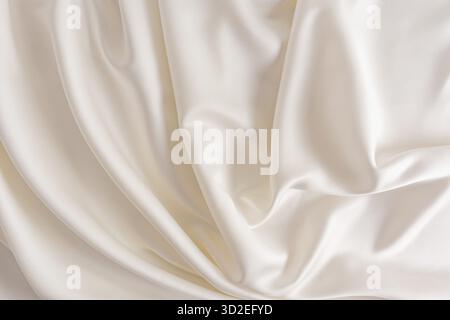 Chic beige or champagne satin fabric for wedding design. abstract background. soft delicate folds of fabric Stock Photo