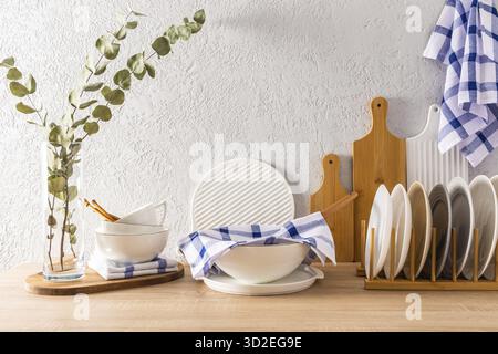 Modern kitchen interior with various kitchen utensils on a wooden countertop. bowls, cutting wooden boards, plates. front view. clean house Stock Photo