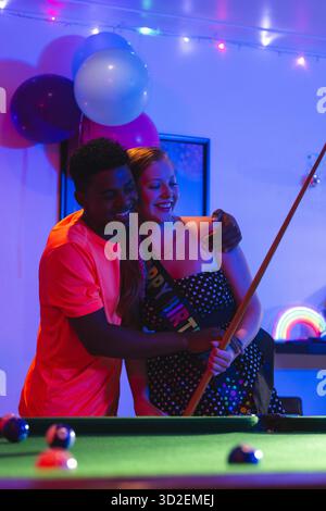 Teenagers celebrating birthday playing pool, smiling and enjoying party atmosphere. celebration, billiards, fun, friendship, leisure, happiness || Model released Stock Photo