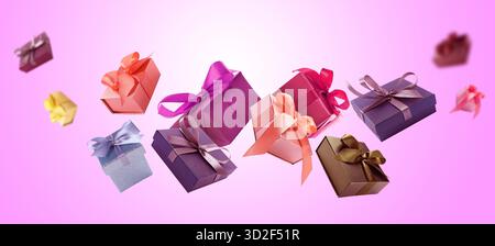 Gift boxes flying in air on magenta gradient background Stock Photo