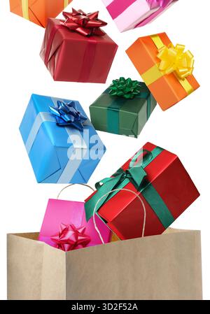 Many gift boxes falling into paper bag on white background Stock Photo