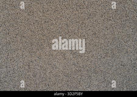 Close-up showing tan and gray asphalt texture forming a detailed grainy surface, perfect for backgrounds, abstract patterns, and construction material Stock Photo