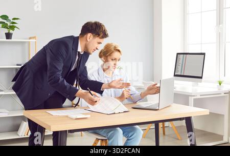 Two fellow partners are working together on joint business project in modern office. Stock Photo