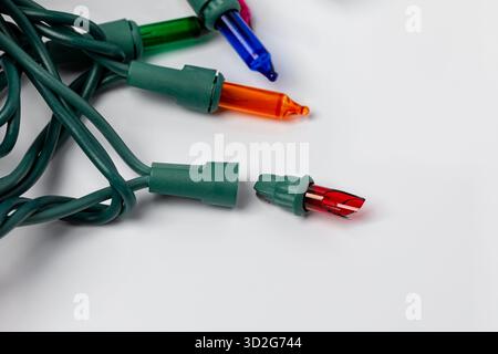 Broken bulb in Christmas string lights. Holiday lighting repair, safety and decoration concept. Stock Photo