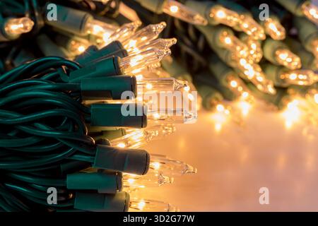 New Christmas string lights turned on and glowing. Holiday decoration safety and lighting concept. Stock Photo