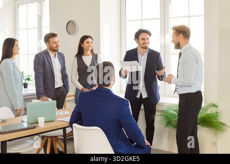 Young happy motivated business team talking at meeting in office conference room, brainstorming Stock Photo