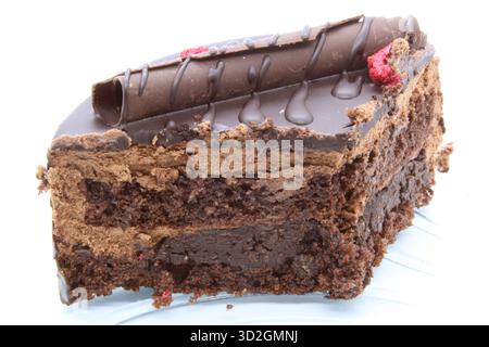 Close-up of a slice of a multi-layered chocolate cake. The layers of dark sponge cake and chocolate cream mousse are clearly visible. The dessert is d Stock Photo