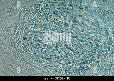 abstract image of water surface in a swimming pool. swirling and rippled surface of a swimming pool with patterns formed on the waters surface. Stock Photo
