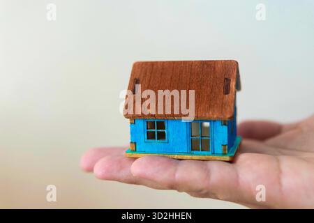 House model in home insurance broker agent hand or in salesman person. Real estate agent offer house Stock Photo