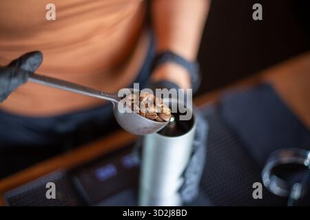 Selective focus brown roasted coffee beans In the coffeemaker's spoon Use a spoon to scoop out fragrant brown, freshly brewed coffee beans. Stock Photo