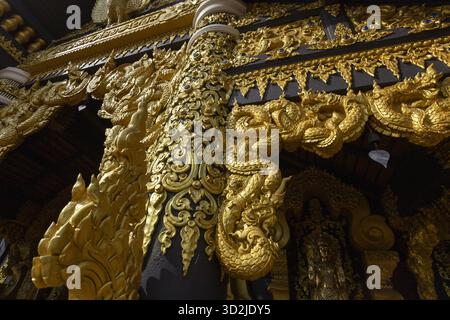 Magnificent golden ornate architectural carving from traditional temple design, featuring an intricate pattern. lavish decoration evokes sense of awe Stock Photo