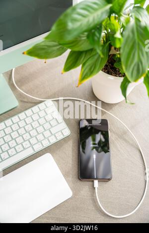 Prague, Czech republic - October 31, 2025: iPhone in restore mode lying on desk connected to computer. Smartphone malfunction, iOS recovery, software Stock Photo
