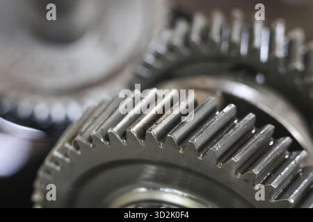 Close up of interlocking metal gears showing complex mechanical system conveying precision and intricate engineering. metallic texture and detailed te Stock Photo
