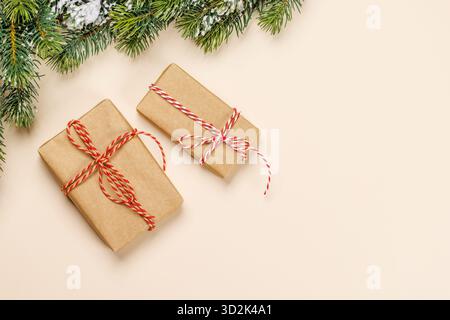 Christmas card with fir branches and gift boxes on beige surface, festive holiday Stock Photo