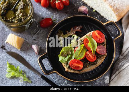 Fresh mediterranean bruschetta with cherry tomatoes and basil on grilled bread. Stock Photo