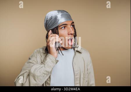 Young man with surprised expression talking on phone Stock Photo