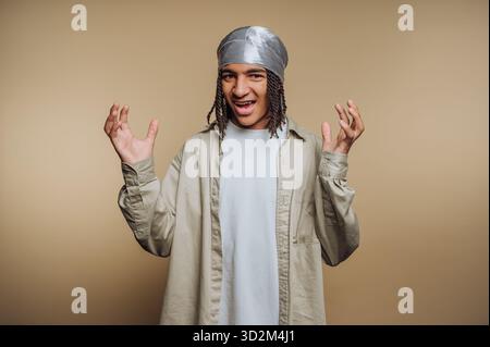 Young man with braided hair and bandana gesturing with hands Stock Photo