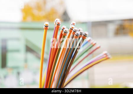Bundle of colorful fiber optic cable in a green blurred background, optical fiber Stock Photo