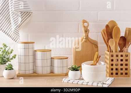 Beautiful kitchen background with set of cutting boards, wooden spoons, bowls, ceramic stylish storage jars. Front view. Eco-friendly kitchen Stock Photo