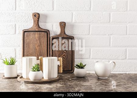 Stylish kitchen backdrop with dark wooden cutting boards and beautiful modern mugs. front view. Eco items Stock Photo