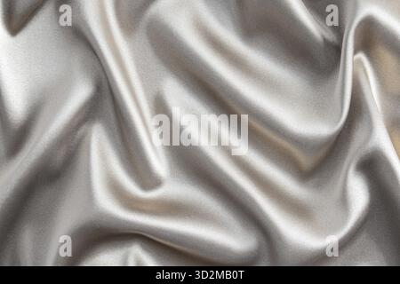 Abstract satin silver background of luxurious fabric. soft gentle waves of fabric. The golden texture of the fabric. Festive, New Year's background Stock Photo