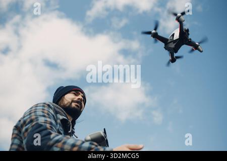 Man pilot Launches quadcopter drone from hand to sky flight Stock Photo