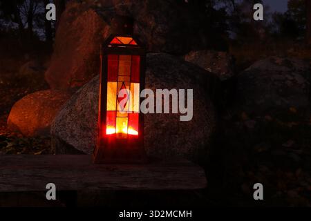 One red and yellow lantern at night. Cosy evening light from the candle. Blurred or blurry background. Stock Photo