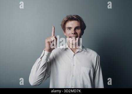 Young man pointing and forefinger index finger up Stock Photo