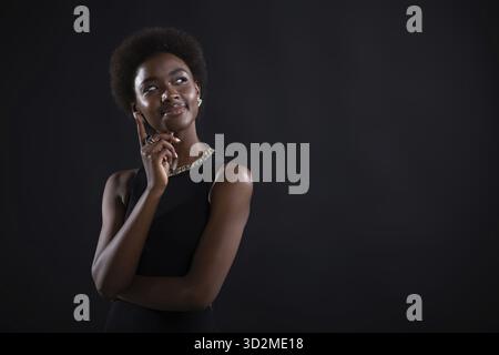 Young black woman trying to find best solution and searching answer. African american female having doubtful expression looking side away and holding Stock Photo