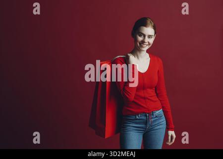 Pretty woman smilng portrait with paper red shopping bags. Black friday and sale Stock Photo