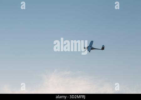 Small single engine airplane flying against sunset sky Stock Photo