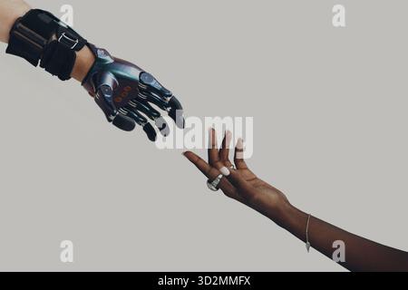 Male hand prosthesis cyborg reaching to female human black african hand. Hands touching progress concept Stock Photo