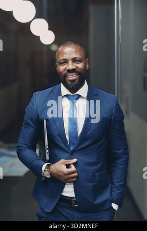 Portrait smiling african-american businessman in blue formal suit in office Stock Photo