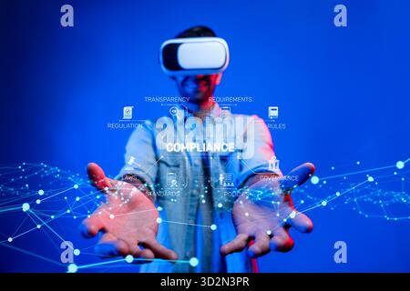 A person using virtual reality goggles engages with compliance concepts in a dynamic digital landscape, emphasizing technology, regulation, and innova Stock Photo