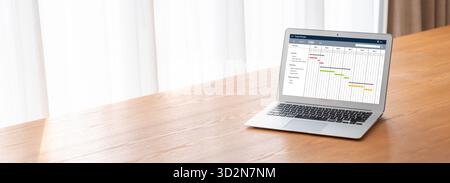 Project planning software for modish business project management on the computer screen showing timeline chart of the team project Stock Photo
