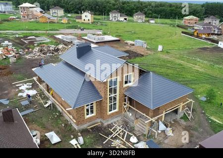 House with a new roof made of metal, Holiday village, view from above. Village in spring from above, houses and vegetable gardens. Stock Photo