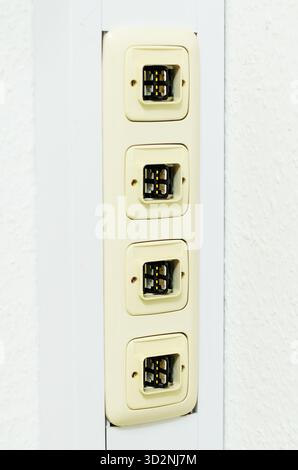 This image shows a close-up of a wall-mounted telephone jack panel with four ports, perfect for telecommunications or networking concepts Stock Photo