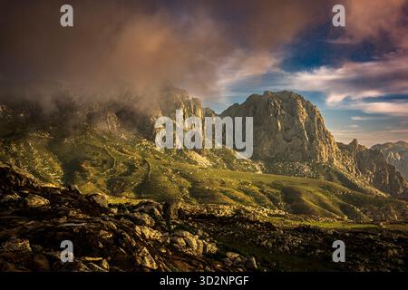 Breathtaking landscape of Hajhir Mountains in Socotra, Yemen during a dramatic sunset. Clouds hover over the rugged terrain. Stock Photo