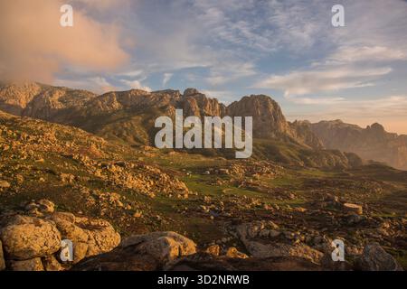 Breathtaking landscape of Hajhir Mountains in Socotra, Yemen during a dramatic sunset. Clouds hover over the rugged terrain. Stock Photo