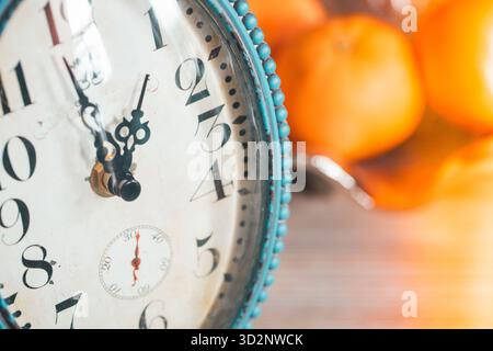 Old-style clock ticking away. 2026. Fruit platter in the background, Copy space. Close-up. Retro style Stock Photo